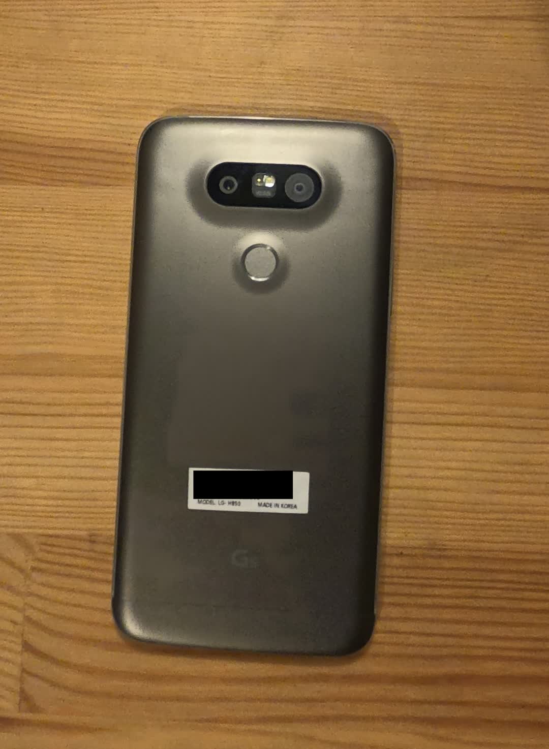 Picture of an LG G5
		smartphone showing its back, including the combined power button and
		fingerprint reader.