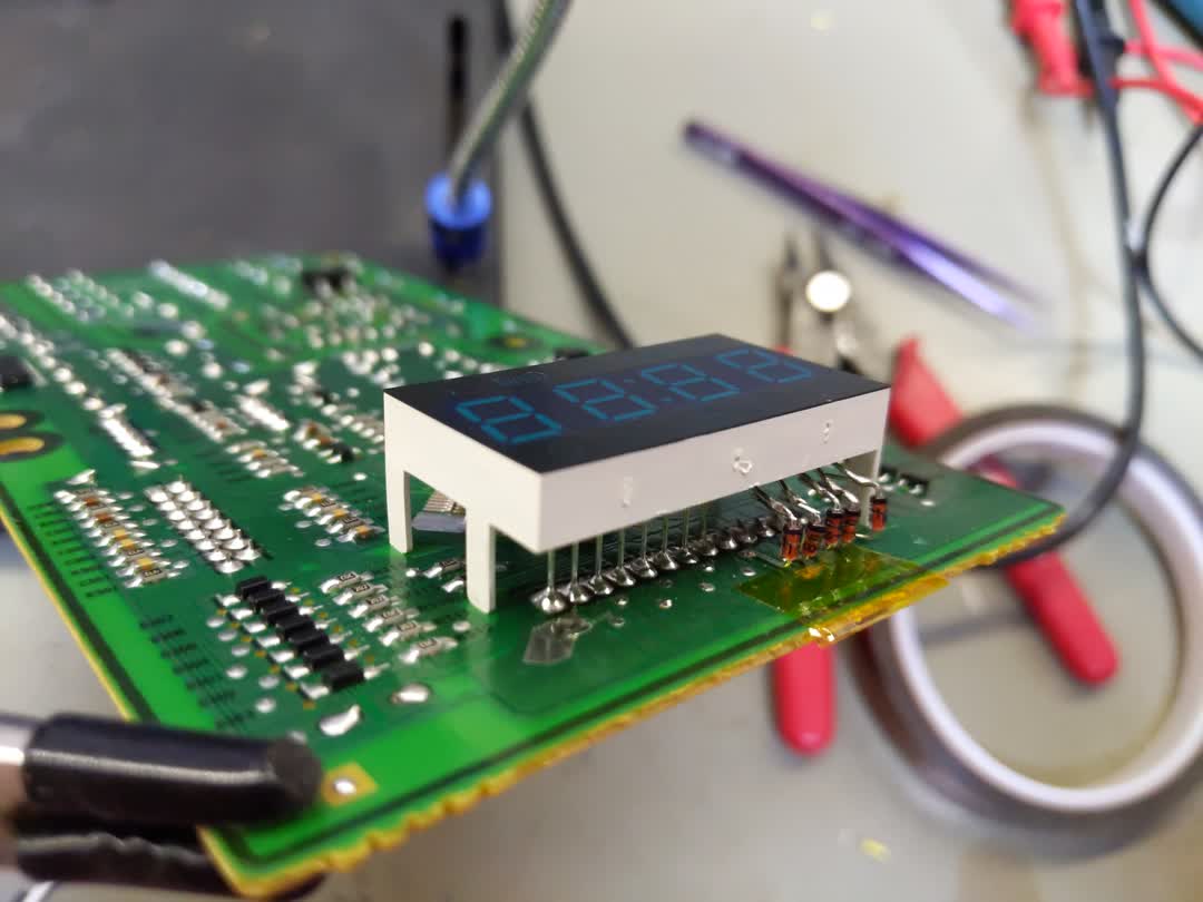 Picture of the
  microwave mainboard completely removed from the microwave. The LCD unit can
  be seen on top of the board, and the newly soldered-in diodes can also be
  seen.