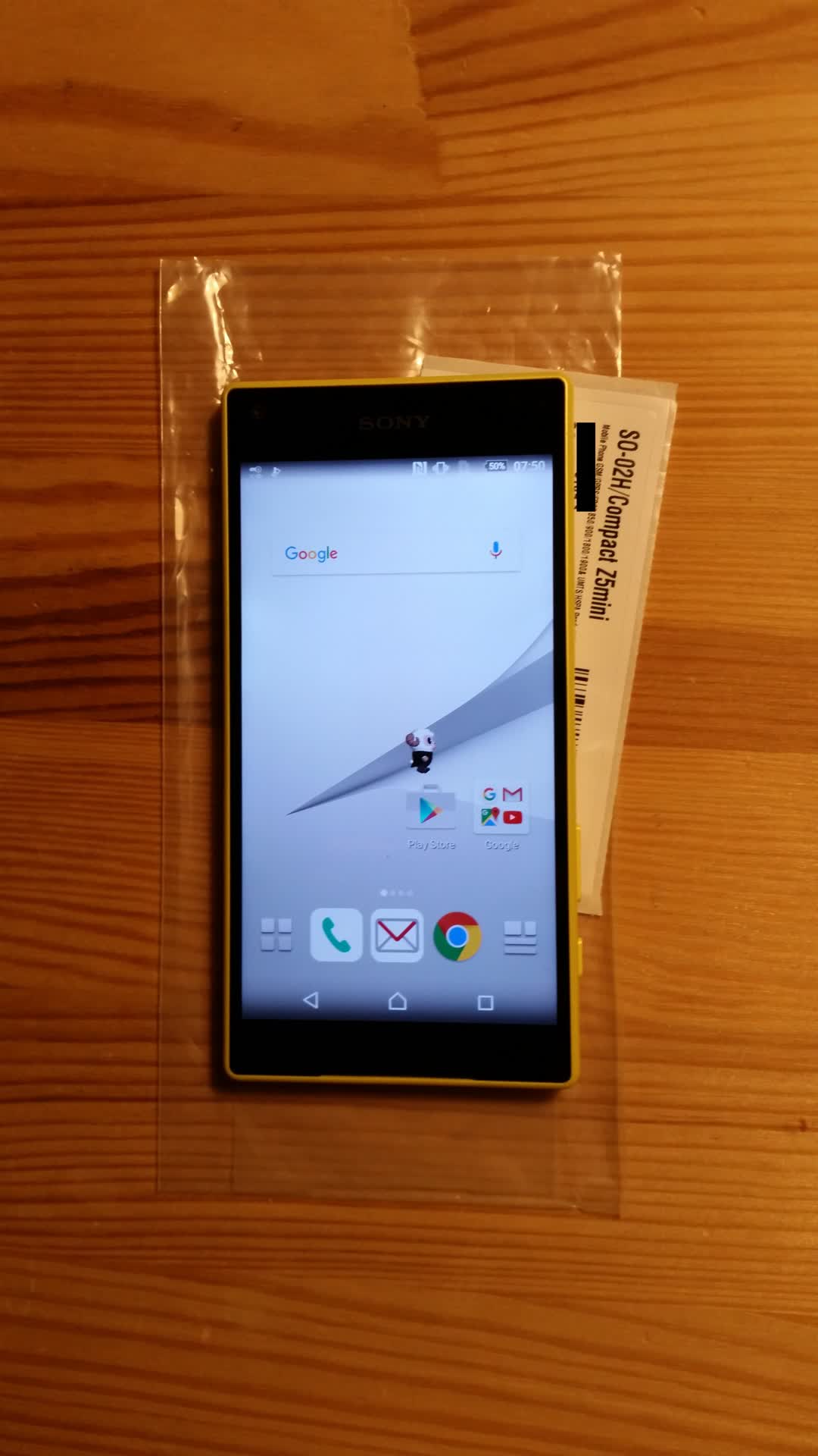 Picture of a Sony
		Xperia Z5 compact smartphone showing its front. The screen is turned on and
		shows the homescreen. You can see an odd little goat character on the
		homescreen.